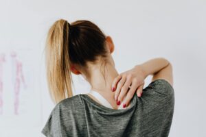 Woman holding shoulder because she's in pain